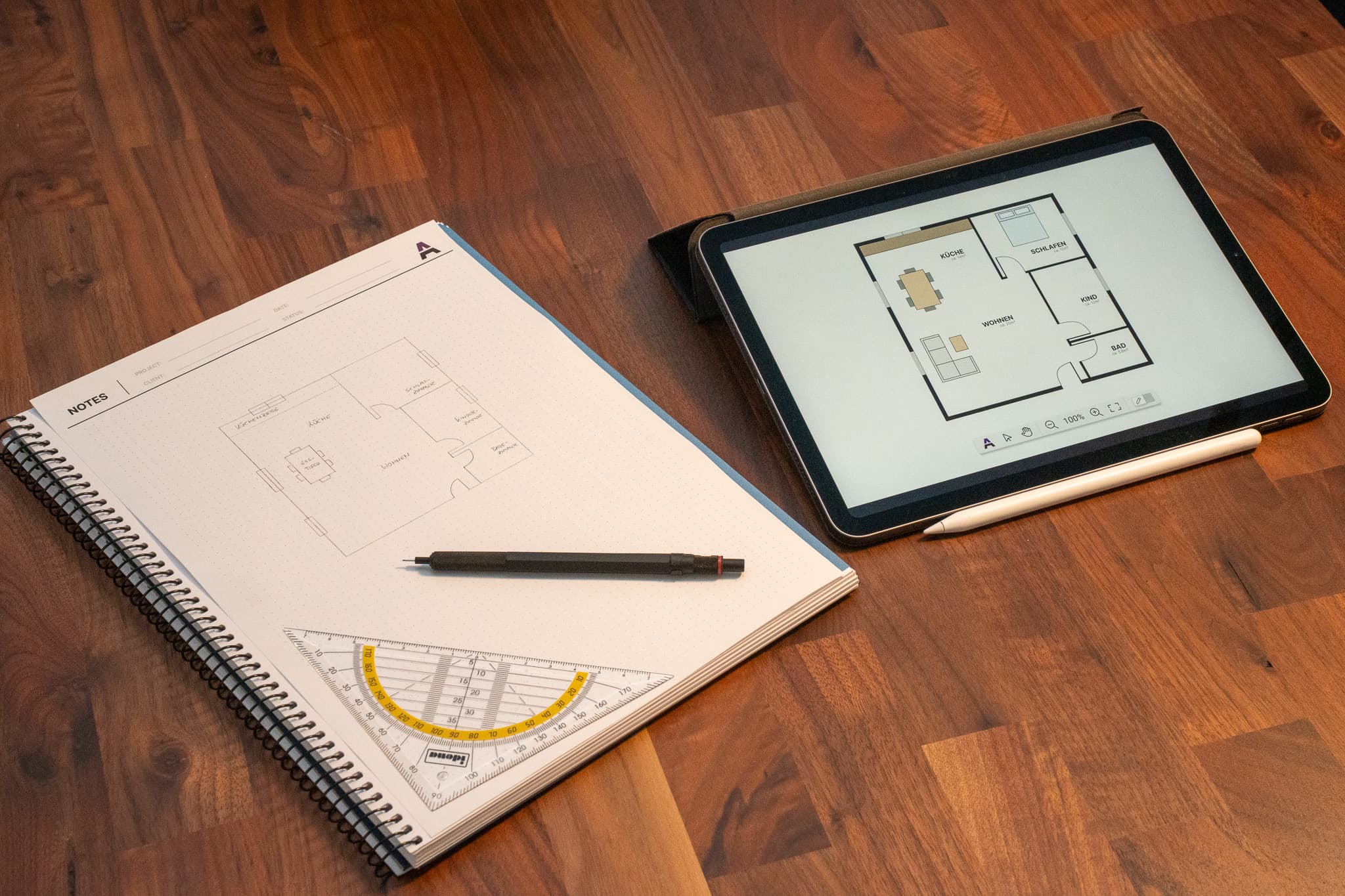 Image of a notebook with a floor plan illustration. Next to it is a tablet with the same floor plan rendered as an SVG on an interactive canvas.